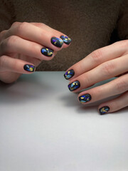 The work of a manicure master. Hands of a beautiful young woman and modern design.