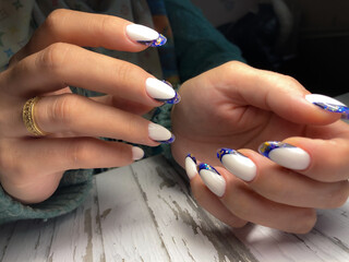 The work of a manicure master. Hands of a beautiful young woman and modern design.