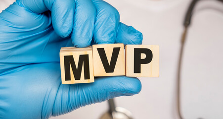 MVP Mitral valve prolapse - word from wooden blocks with letters holding by a doctor's hands in medical protective gloves. Medical concept.