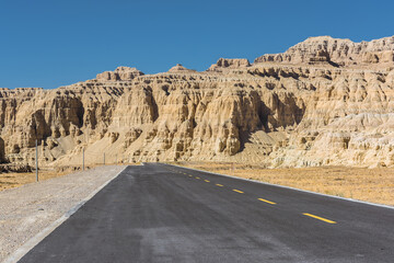 A section of tarmac road in the eroded landscape and rock towers of Zanda soil forest