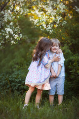 Beautiful twins boy and girl in spring garden - 427034185