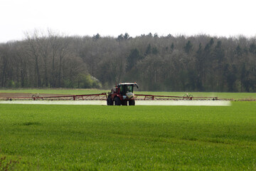 Fototapeta na wymiar Farmer spraying crops In field in spring time In North Yorkshire April UK