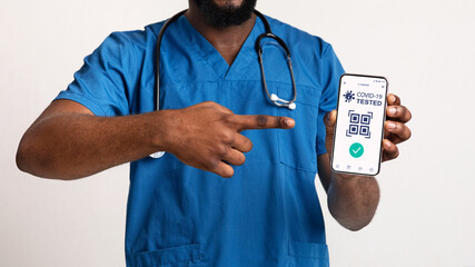 Black doctor showing cellphone with digital e-passport for covid-19