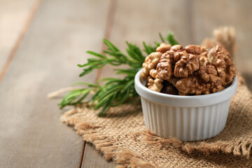 Walnut in white cup on wood background. healthy nuts concept.