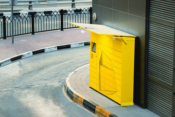Yellow automatic parcel shipment station at city street. Logistic and e-commerce business concept