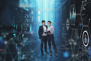 Businessman and businesswoman are standing between two digital i