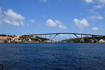 Naklejka premium view across St. Anna Bay in Willemstad towards Queen Juliana bridge along the waterfront in the Otrobanda quarters of Curacao