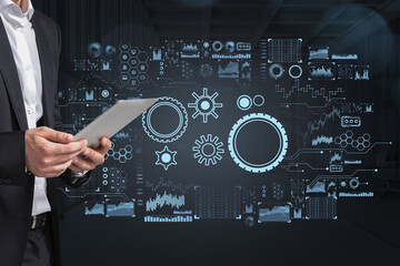 Businessman with tablet, digital hud with gears and diverse icons, stock market