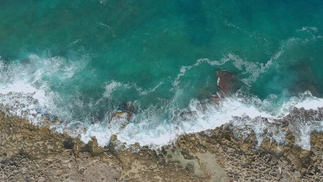 Aerial top view of the waves breaking on the rocks of Mola di Bari, Apulia. Bird's eye view of the waves breaking on the rocks