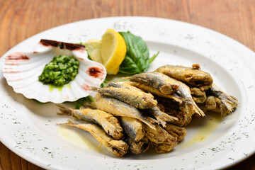 Plate of deep fried anchovies with lemon and salad