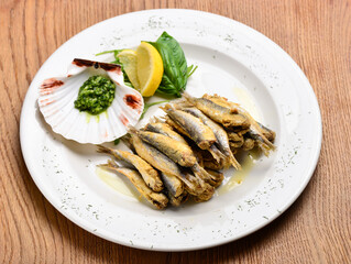 Plate of deep fried anchovies with lemon and salad