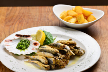 Plate of deep fried anchovies with lemon and salad