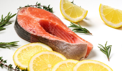 Steak of red fish, salmon with lemon, rosemary and thyme. Trout on white background.