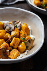 homemade pumpkin gnocchi with mushroom sauce and ricotta