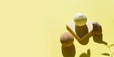 Mock up spa concept with bath bombs and marble stone on wooden geometric shape. Summertime...