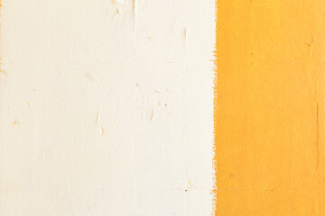 A yellow stripe on a white wall. The wall of the house is painted with white and yellow paint