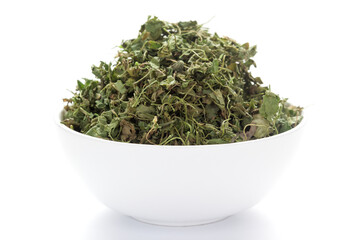 close-up of Organic green dry Fenugreek leaves (Trigonella foenum-graecum) on a ceramic white bowl. Pile of Indian Aromatic Spice