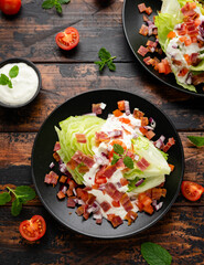 Iceberg wedge salad with bacon, cherry tomatoes, red onion and dressing. healthy food
