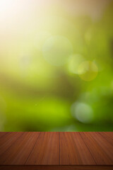 Empty wooden deck table with green spring bokeh background.