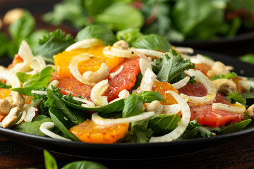 Fresh salad with fennel, orange, grapefruit, spinach and cashew nuts. healthy food.