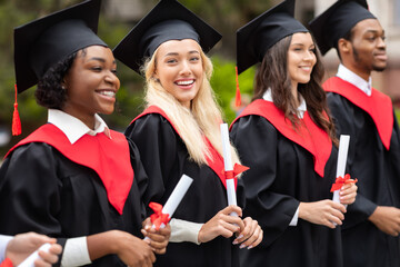 Pretty blonde lady standing among international group of students