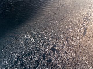 Pieces of ice and slush formed by wind at freezing lake water