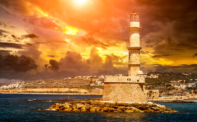 of the beautiful old harbor of Chania with the amazing lighthouse, mosque, venetian shipyards, at sunset, Crete, Greece.