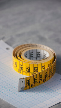 Cinta métrica amarilla y blanca enrollada sobre papel milimetrado Stock  Photo | Adobe Stock