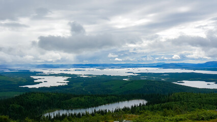 Fototapeta na wymiar View from the highest point near Arjeplog in Sweden. This view is towards the lake Hornavan in Sweden, in Norrbotten County - Lapland. One of the many wetlands in Sweden.