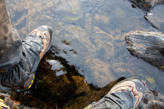 Hiking shoes in very cold water. Showing the endurance of trekking in the wild. Picture made in Sarek National park in Sweden. One of the most remote places in Europe.