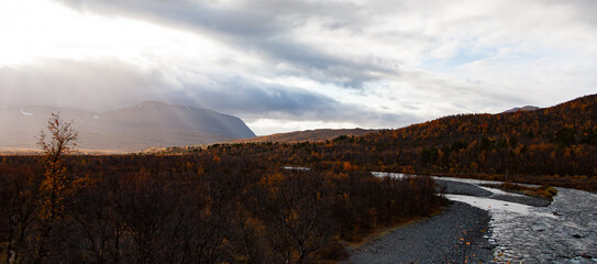 River view in Abisko National Park during fall conditions. Mountainous nature reserve, rich in animal life, with waterfalls & hiking trail in the park's south.