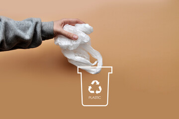 A man throws a plastic bag into a dumpster. Sorting and recycling of garbage