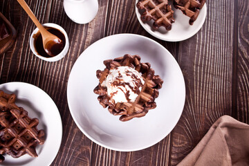 Homemade chocolate waffles with ice cream decorated chocolate syrup.