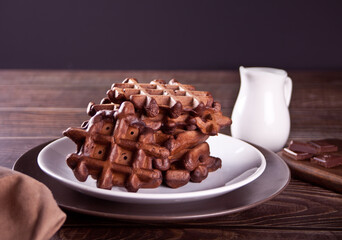 Homemade chocolate waffles on the wooden table.