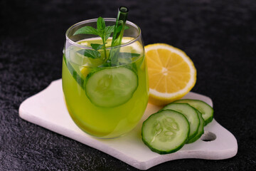A glass of slimming drink with cucumber, lemon and mint.
