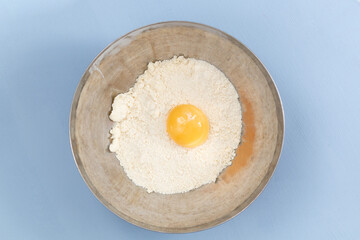 pastry preparation, broken egg with flour in a bowl
