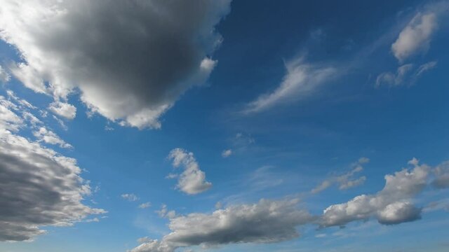 Different types of clouds pass by bright sky in Spring, time lapse