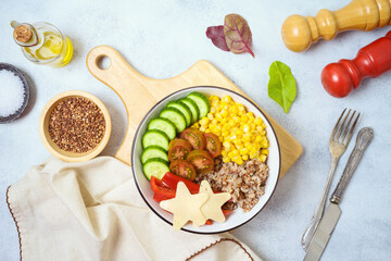 Buddha bowl with buckwheat, tomatoes, cucumber, red sweet pepper, corn and cheese on rustic table. Healthy eating and dieting concept