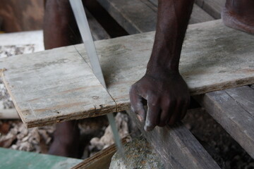 Black man sawing wood