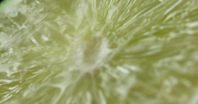 Close-up of the green lime incision through which a drop of water flows and drains