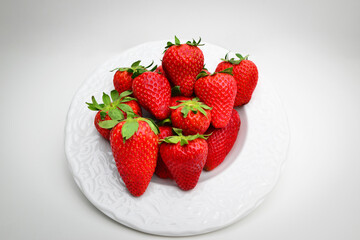 Mountain of ripe red strawberries. Strawberries in plate isolated on white background. Organic fresh strawberry from garden. Plate with juicy strawberries on white background.