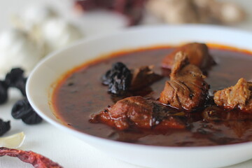 fish curry with red gravy prepared in traditional kerala style. Fish used is Bluefin trevally, locally known as vatta