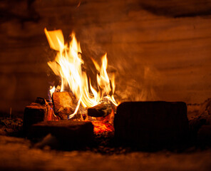 A campfire burns in the snow at night in the snow in the cold winter