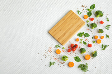 Naklejka na ściany i meble Empty wooden cutting board with vegetables and greens on white textured vintage background, copy space.