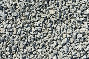Construction materials for road works. The texture of gray broken stone or rubble as a natural background.