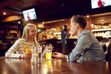 Man and woman drinks alcohol and talking in bar