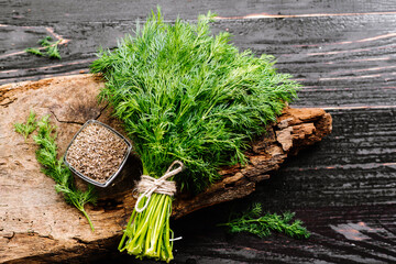 Dry seeds with raw dill on wooden background - 427059387