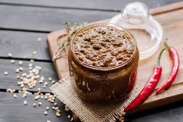 mixed sauce with different spicy herbs in glass bowl on wooden background