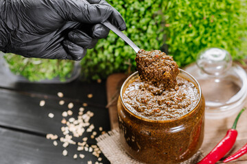 mixed sauce with different spicy herbs in glass bowl on wooden background