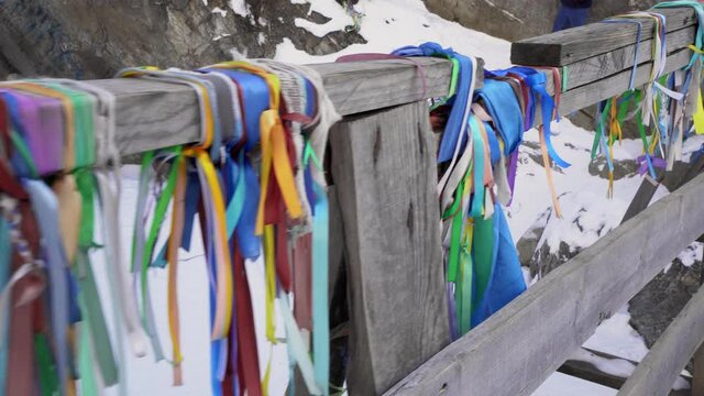 Colorful Ribbons Tied around Handrail of Wooden Bridge over Kyngarga River in Tunka Valley, Buryatia, Russia